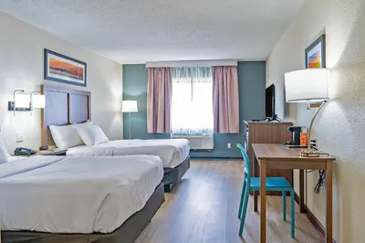 a hotel room with two beds and a desk at Quality Inn Milan-Sandusky in Milan