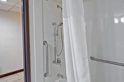 a shower with a shower curtain in a bathroom at Quality Inn Milan-Sandusky in Milan