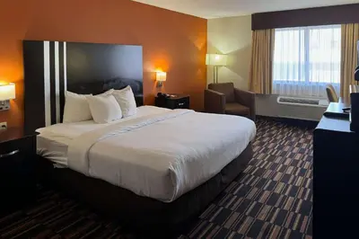 a hotel room with a large bed and a chair at Comfort Inn Maumee - Perrysburg Area in Maumee