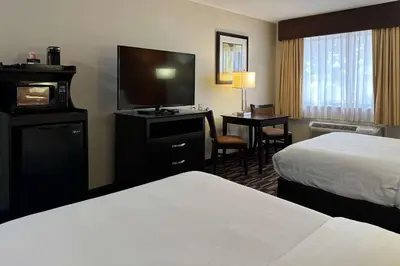 a hotel room with a bed and a flat screen tv at Comfort Inn Maumee - Perrysburg Area in Maumee