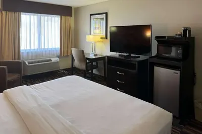 a hotel room with a bed and a flat screen tv at Comfort Inn Maumee - Perrysburg Area in Maumee