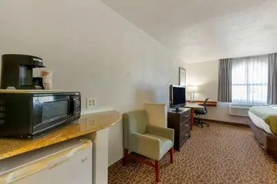 a hotel room with a bed and a desk with a television at Quality Inn Alexis Rd in Toledo