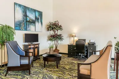 a hotel room with chairs and a desk and a tv at Quality Inn Jackson in Jackson