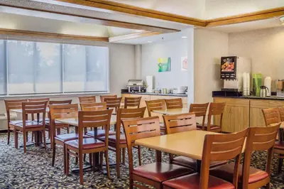 a dining room with tables and chairs and a kitchen at Quality Inn Port Clinton Waterfront in Port Clinton
