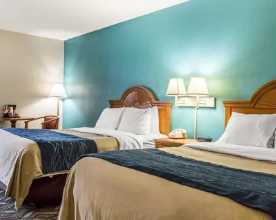 a hotel room with two beds and a blue wall at Quality Inn & Suites Circleville in Circleville