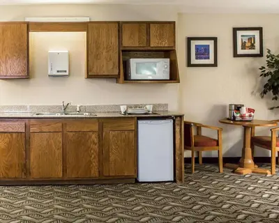 a kitchen with a sink and a refrigerator and a table at Quality Inn & Suites Circleville in Circleville