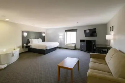 a hotel room with a bed and a couch and a tub at Quality Inn & Suites Circleville in Circleville
