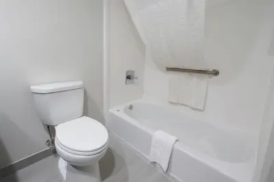 a white bathroom with a toilet and a bath tub at Quality Inn & Suites Circleville in Circleville