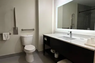 a bathroom with a toilet and a sink and a mirror at Quality Inn & Suites Circleville in Circleville