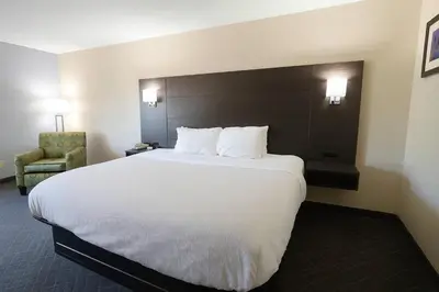 a hotel room with a large bed and a chair at Quality Inn & Suites Circleville in Circleville