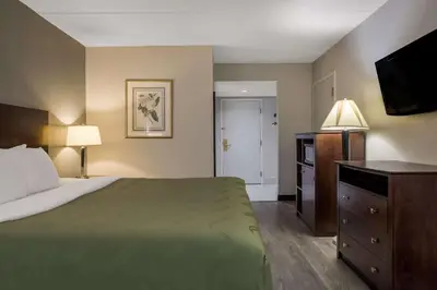a hotel room with a bed and a flat screen tv at Quality Inn Toledo Westgate in Toledo