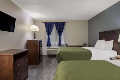 a hotel room with two beds and a television at Quality Inn Toledo Westgate in Toledo