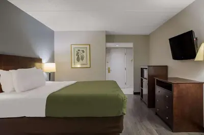 a bedroom with a bed and a flat screen tv at Quality Inn Toledo Westgate in Toledo