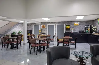 a restaurant with tables and chairs and a kitchen at Quality Inn Toledo Westgate in Toledo