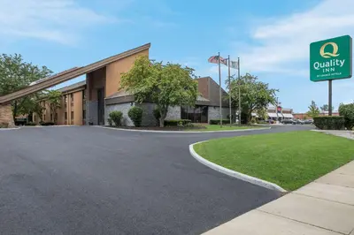 a building with a sign in front of a road at Quality Inn Toledo Westgate in Toledo