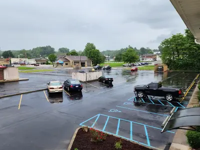 a parking lot with cars parked in the rain at Quality Inn Wheelersburg in Wheelersburg