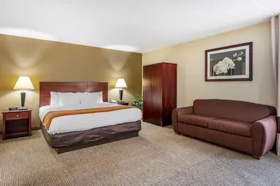 a hotel room with a bed and a couch at Comfort Inn Cincinnati Northeast in Mason
