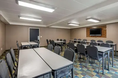 a conference room with tables and chairs and a screen at Comfort Inn Cincinnati Northeast in Mason
