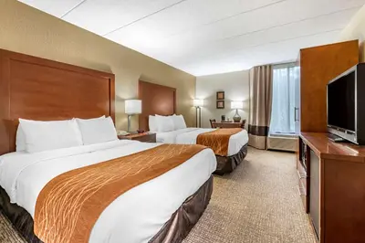 a hotel room with two beds and a flat screen tv at Comfort Inn Cincinnati Northeast in Mason