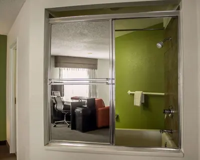 a mirror in a room with a chair and a desk at Sleep Inn Sandusky in Sandusky