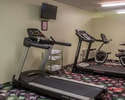 a gym with two tread machines and a tv at Sleep Inn Sandusky in Sandusky