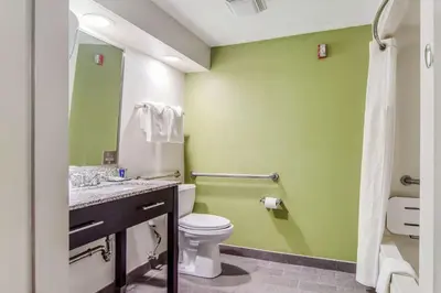 a bathroom with a toilet and a green wall at Sleep Inn Austintown - Youngstown, West in Austintown