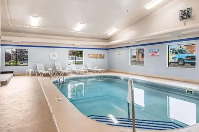 a pool in a large room with chairs and a table at Sleep Inn Austintown - Youngstown, West in Austintown