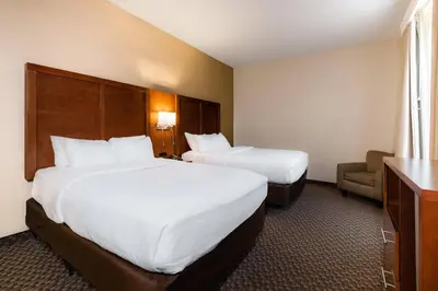 a hotel room with two beds and a chair at Comfort Suites Troy-I75 in Troy
