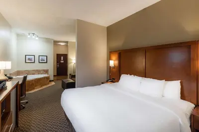 a hotel room with a large bed and a bathroom at Comfort Suites Troy-I75 in Troy