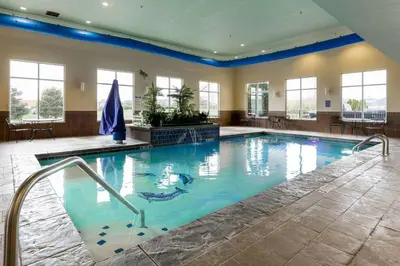 a large swimming pool with blue water at Comfort Suites Troy-I75 in Troy