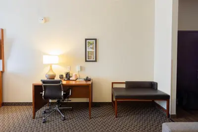 a room with a desk and a chair and a lamp at Comfort Suites Troy-I75 in Troy