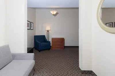 a living room with a couch and a blue chair at Comfort Suites Troy-I75 in Troy