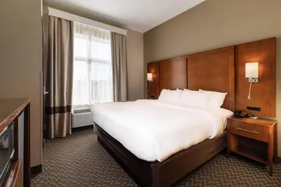 a hotel room with a large bed and a window at Comfort Suites Troy-I75 in Troy