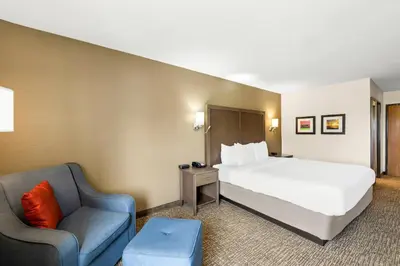 a hotel room with a bed and a chair at Comfort Inn Van Wert in Van Wert