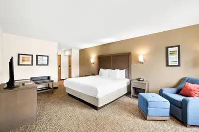 a hotel room with a bed and a blue chair at Comfort Inn Van Wert in Van Wert