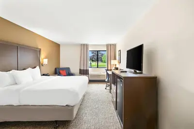 a hotel room with a bed and a flat screen tv at Comfort Inn Van Wert in Van Wert