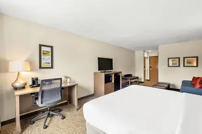 a hotel room with a bed and a desk with a computer at Comfort Inn Van Wert in Van Wert