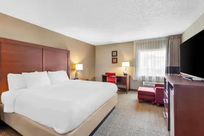 a hotel room with a large bed and a television at Comfort Inn Mayfield Heights Cleveland East in Mayfield