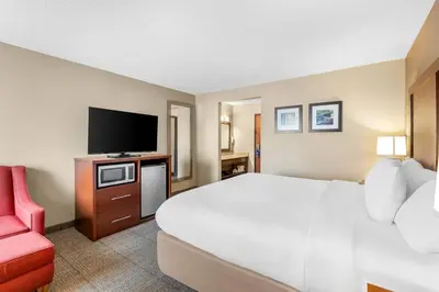 a hotel room with a bed and a flat screen tv at Comfort Inn Mayfield Heights Cleveland East in Mayfield