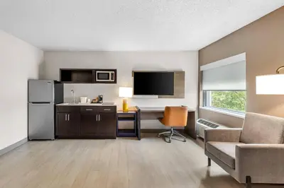 a room with a desk and a refrigerator and a chair at Comfort Inn Mayfield Heights Cleveland East in Mayfield
