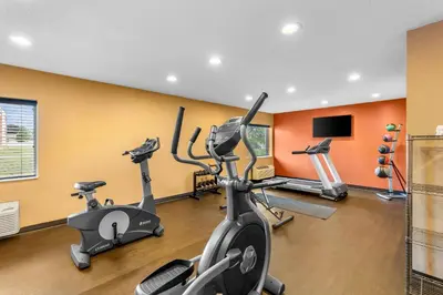 a gym with two exercise bikes and a flat screen tv at Comfort Inn Mayfield Heights Cleveland East in Mayfield