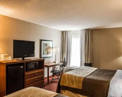 a hotel room with two beds and a flat screen tv at Quality Inn Springboro West in Springboro