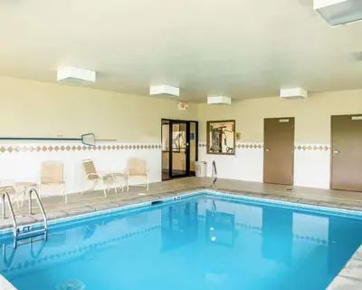 a large swimming pool with chairs and a table at Quality Inn Springboro West in Springboro