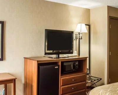 a hotel room with a television on a cabinet with a microwave at Quality Inn Springboro West in Springboro