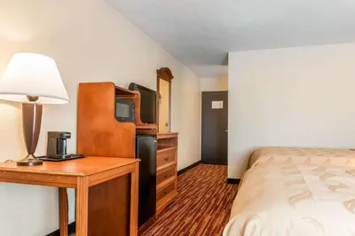 a bedroom with a bed and a desk with a television at Quality Inn Gallipolis in Gallipolis