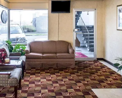 a living room with a couch and a sliding glass door at Economy Inn & Suites in Warren