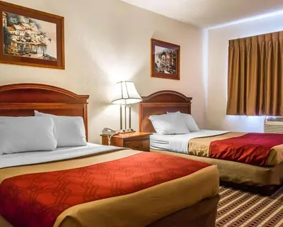 a hotel room with two beds and a window at Economy Inn & Suites in Warren