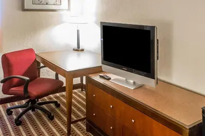 a room with a desk with a television and a chair at Economy Inn & Suites in Warren