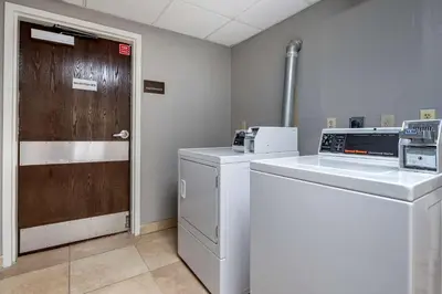a laundry room with a washer and a wooden door at Comfort Inn Oxford - University Area in Oxford