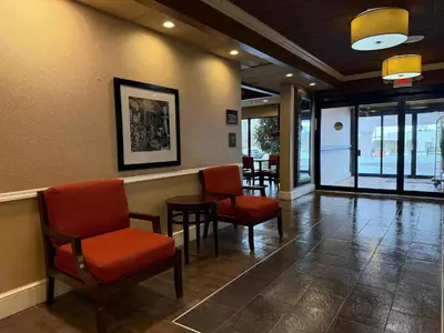a waiting room with chairs and a table and windows at Comfort Inn Oxford - University Area in Oxford